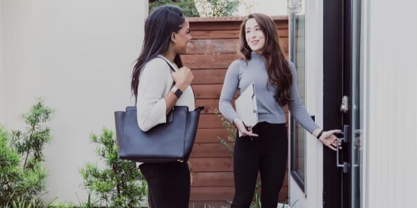 Female real estate agent with client at door